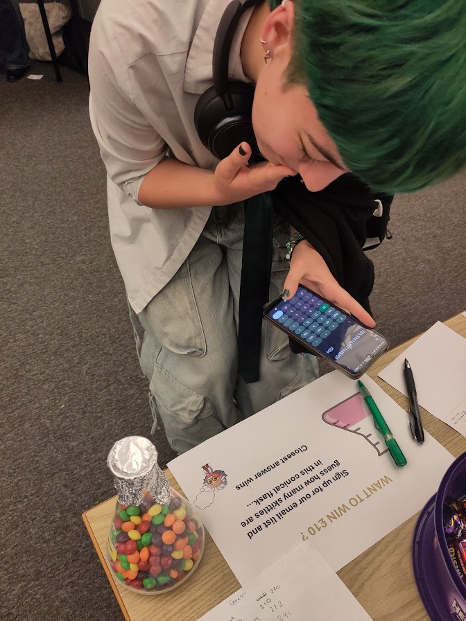 A person guesses how many Skittles are in a conical flask.