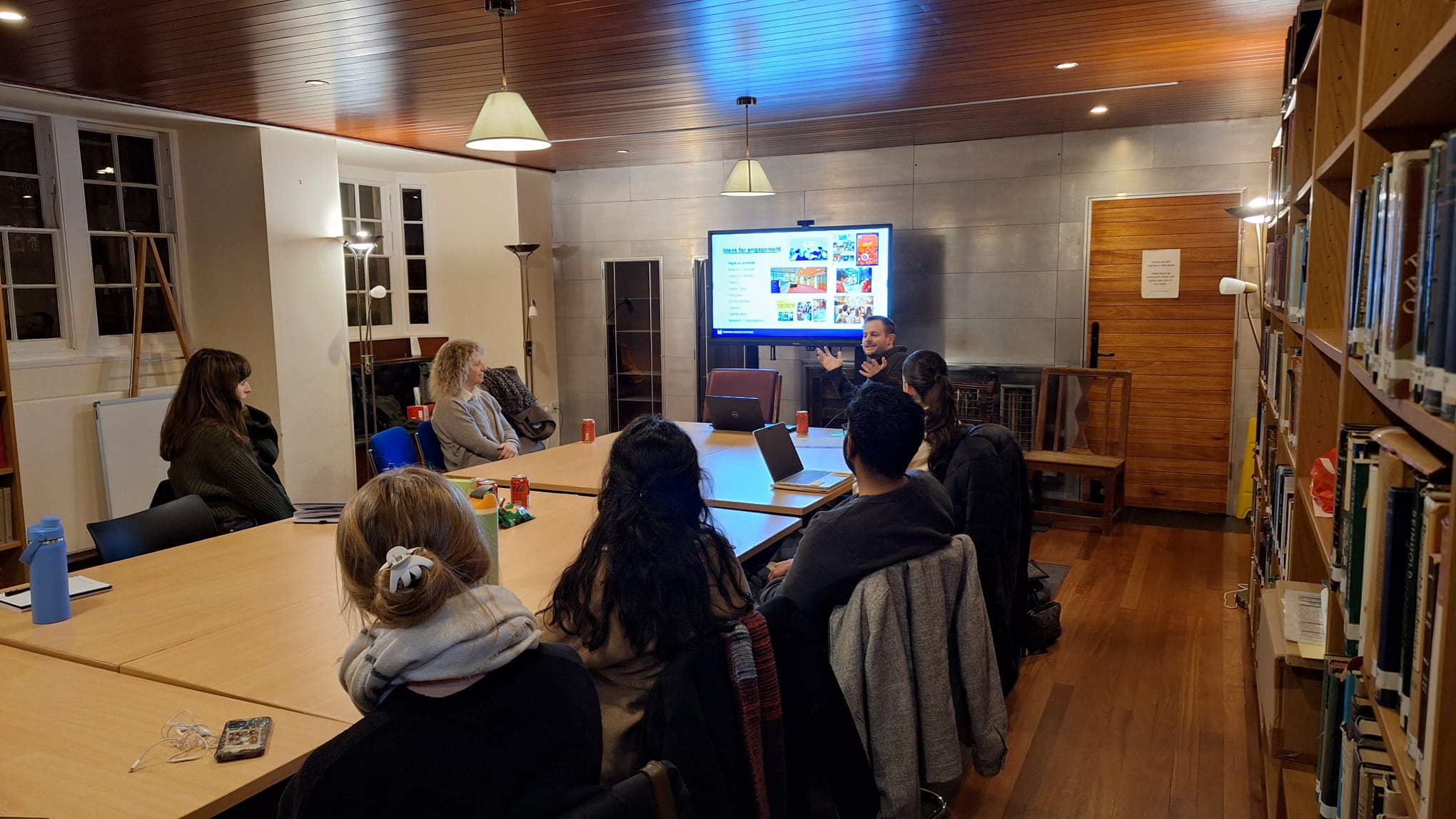 A group of students look on as a man gives a presentation.